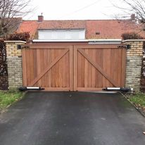 Geautomatiseerde draaipoort in afrormosia hout aan oprit