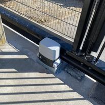 Roger motor voor geautomatiseerde schuifpoort, netjes geplaatst aan de poortrail.