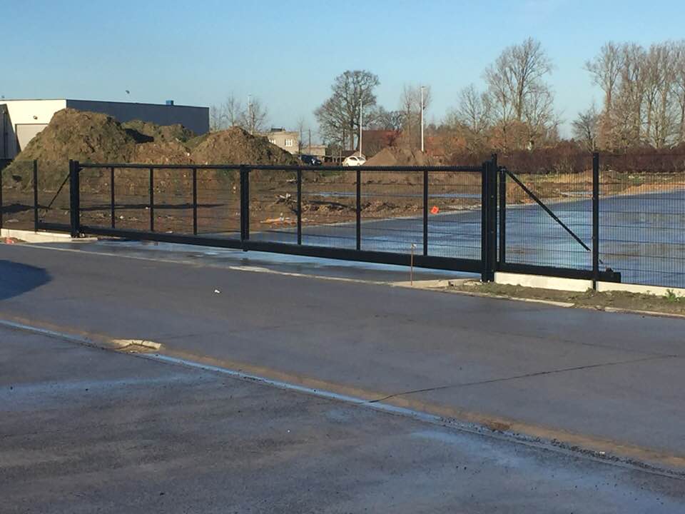 Dubbele geautomatiseerde industriële schuifpoort met staalmatvulling geplaatst in Staden.