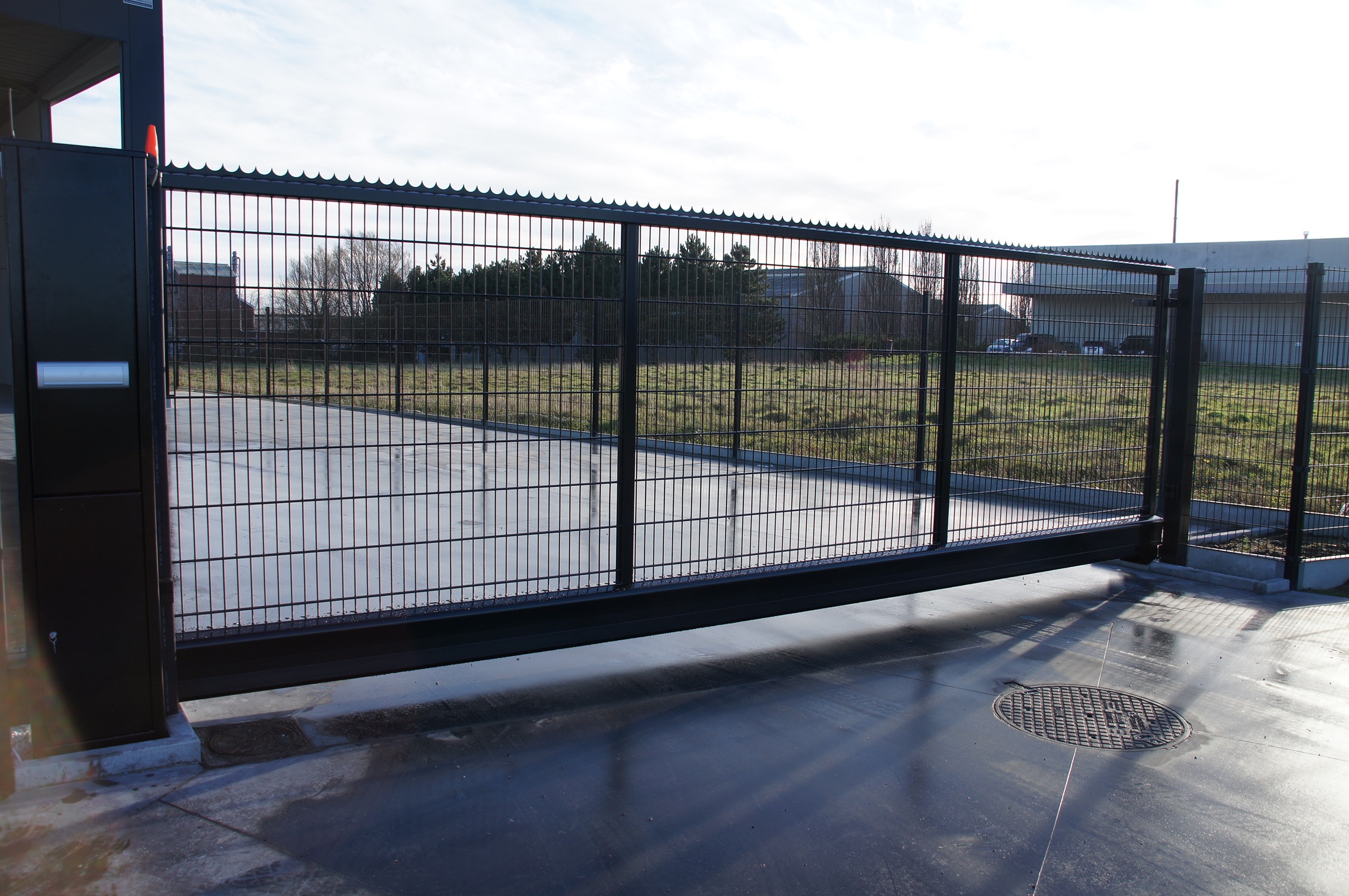 Geautomatiseerde industriële schuifpoort met staalmatvulling bij bedrijfsterrein in Staden