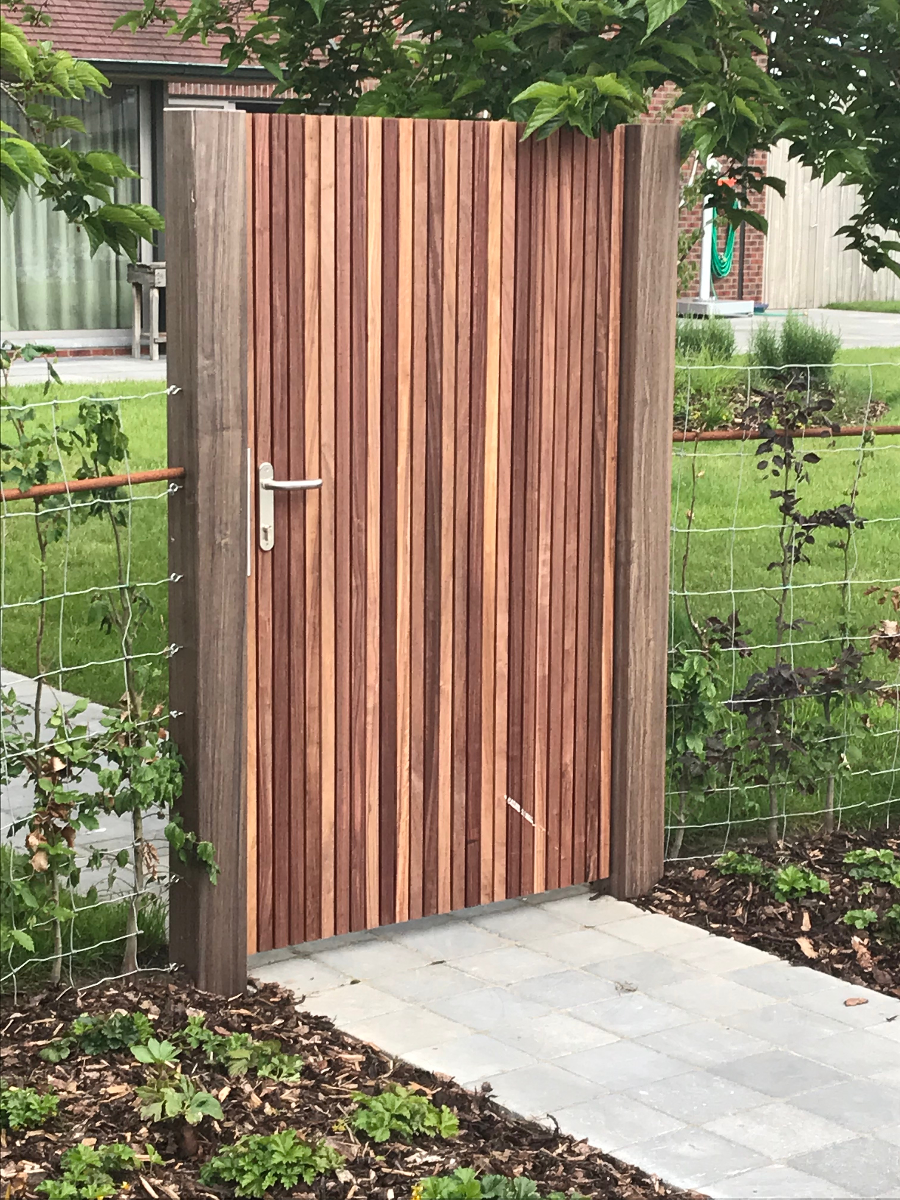 Moderne padouk tuinpoort met verticale latten in Staden