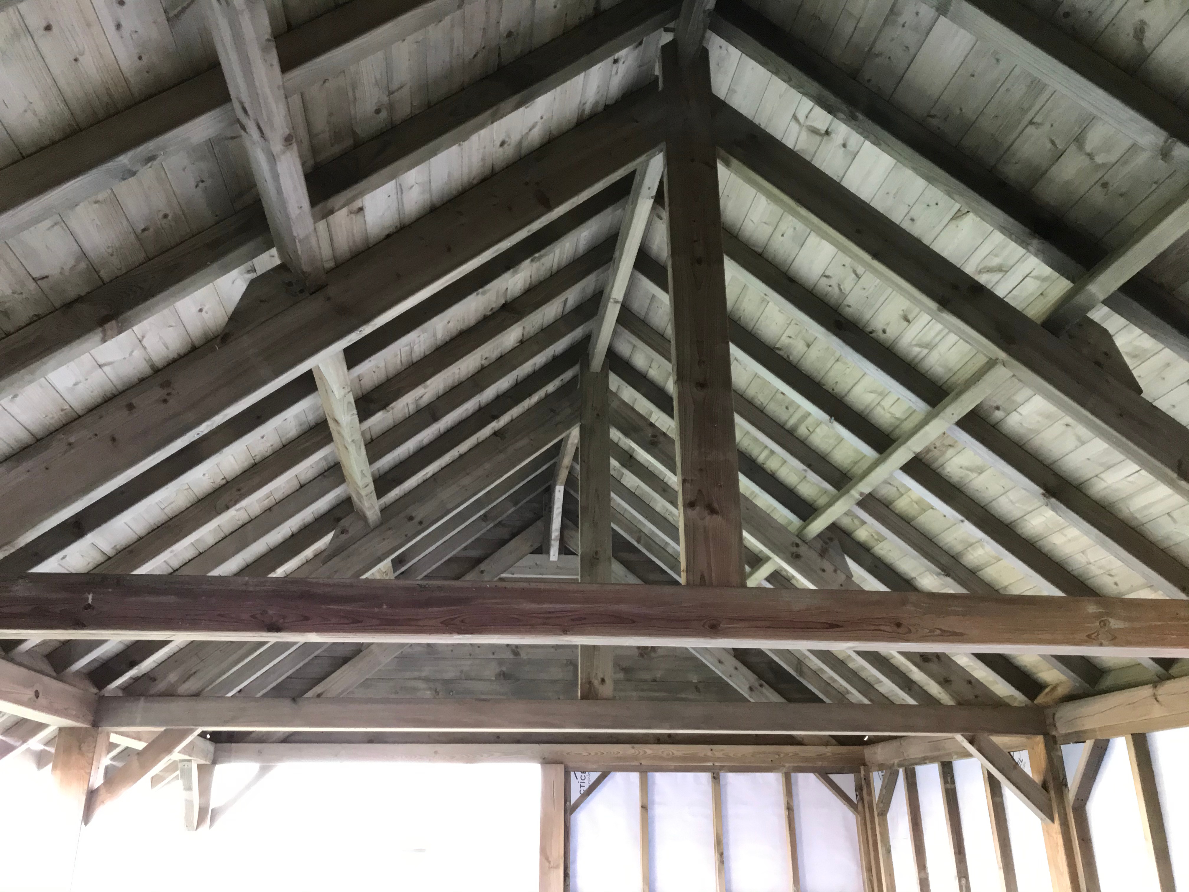 Houten dakconstructie met zichtbare balken in een bijgebouw