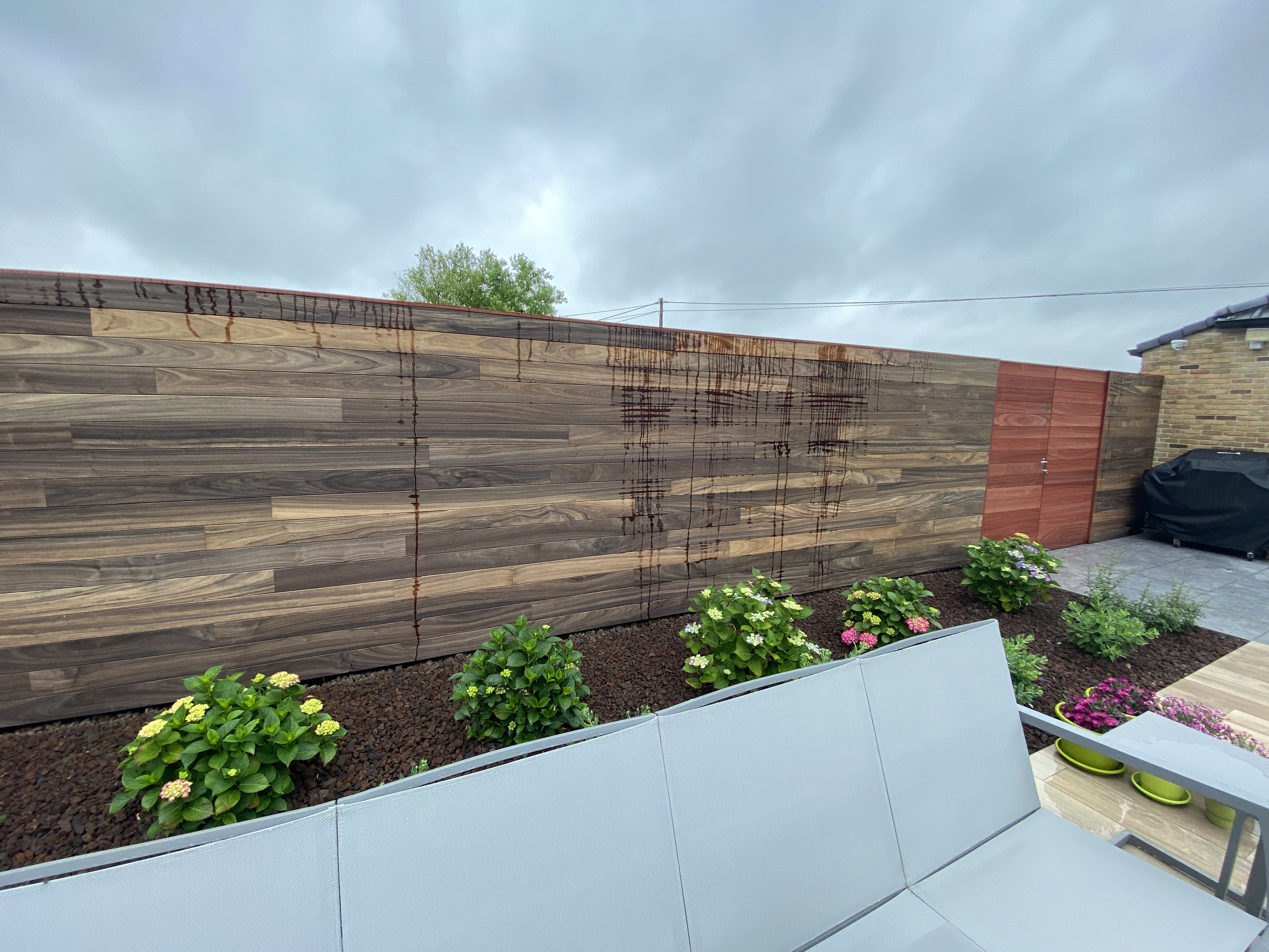 Padouk tuinafsluiting met geïntegreerde houten poort in Edewale