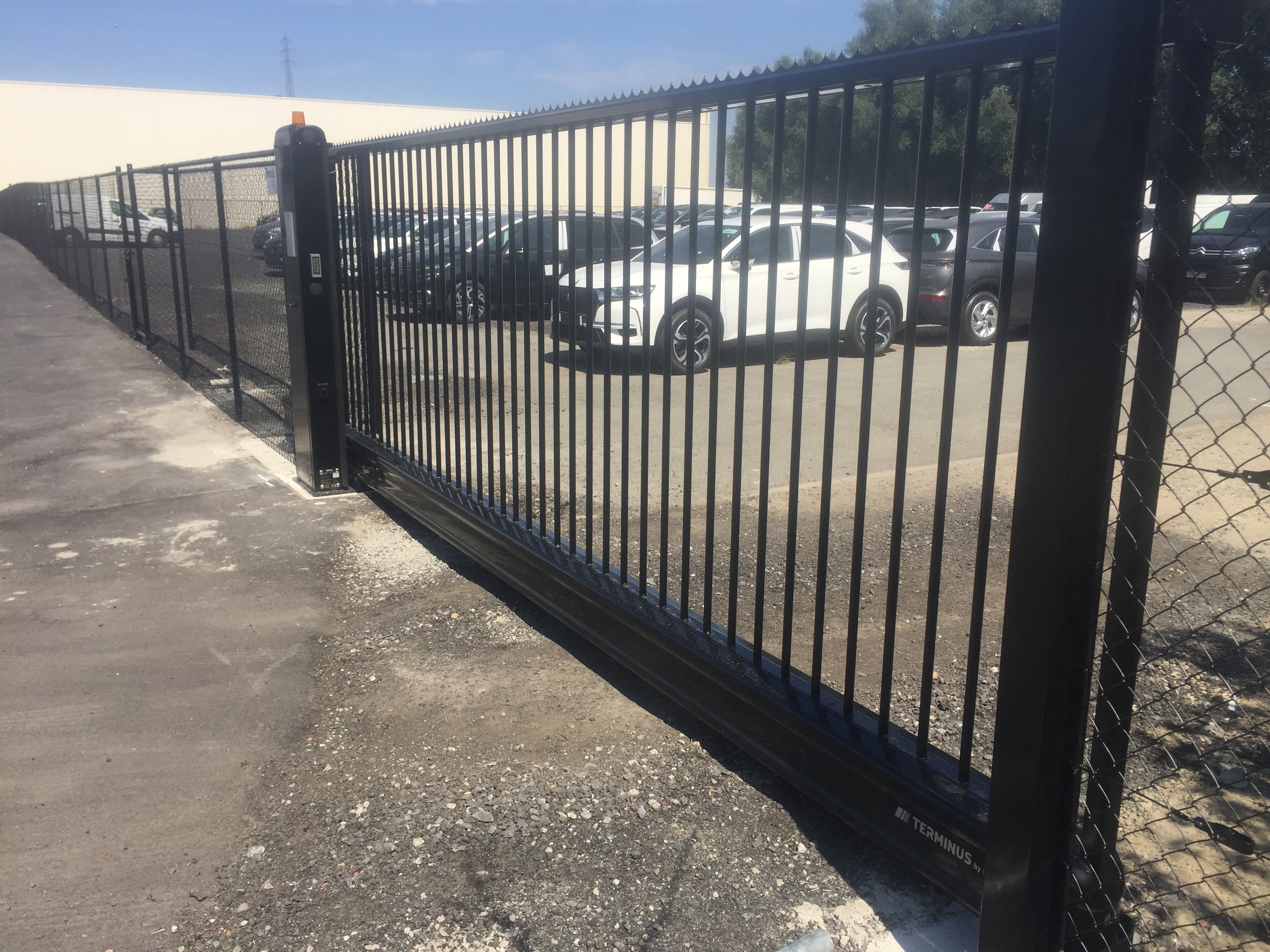 Geautomatiseerde industriële aluminium schuifpoort geplaatst bij een bedrijfsterrein in Gits.