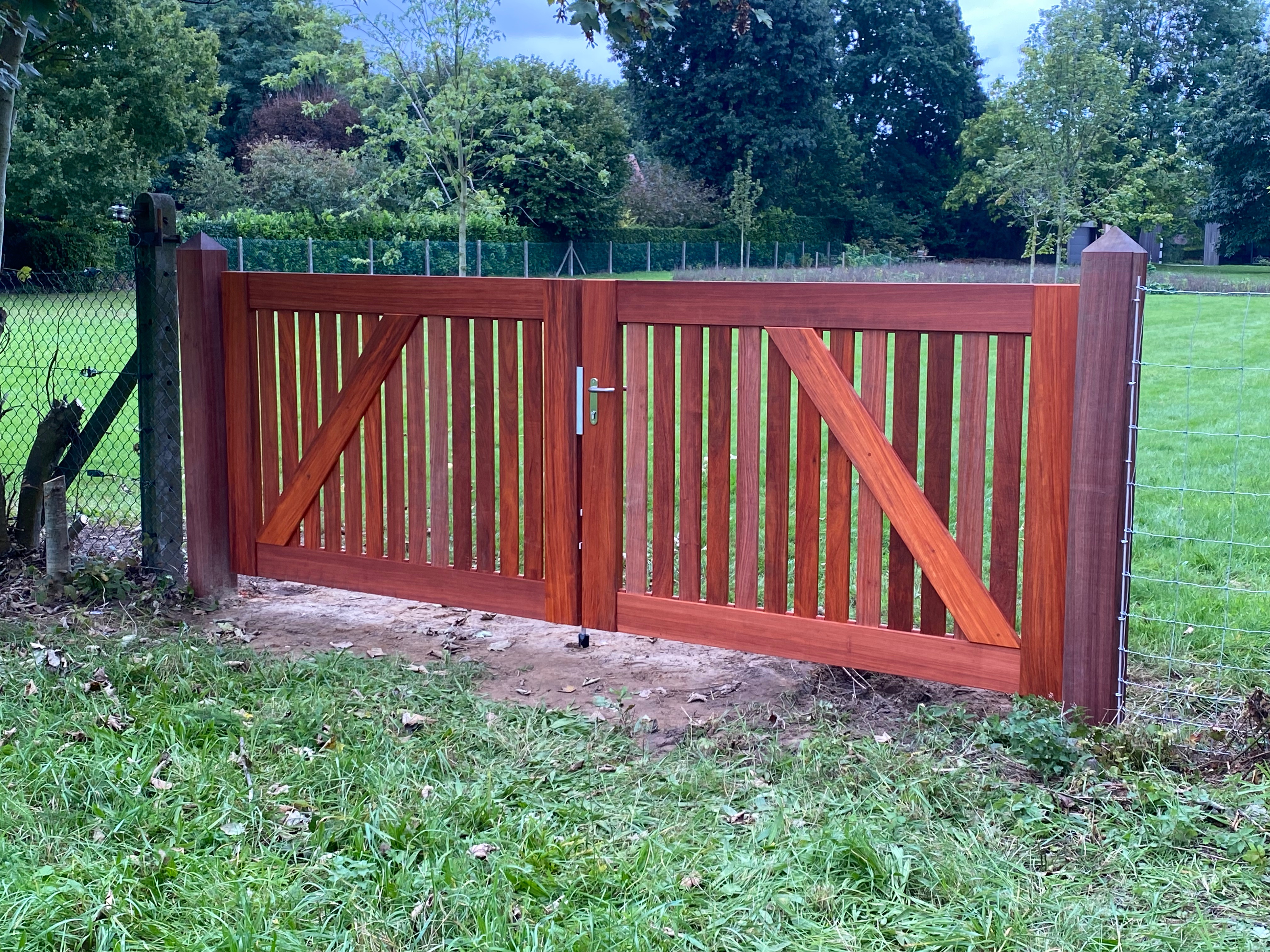 Landelijke houten draaipoort met verticale latten in Sint-Martens-Latem