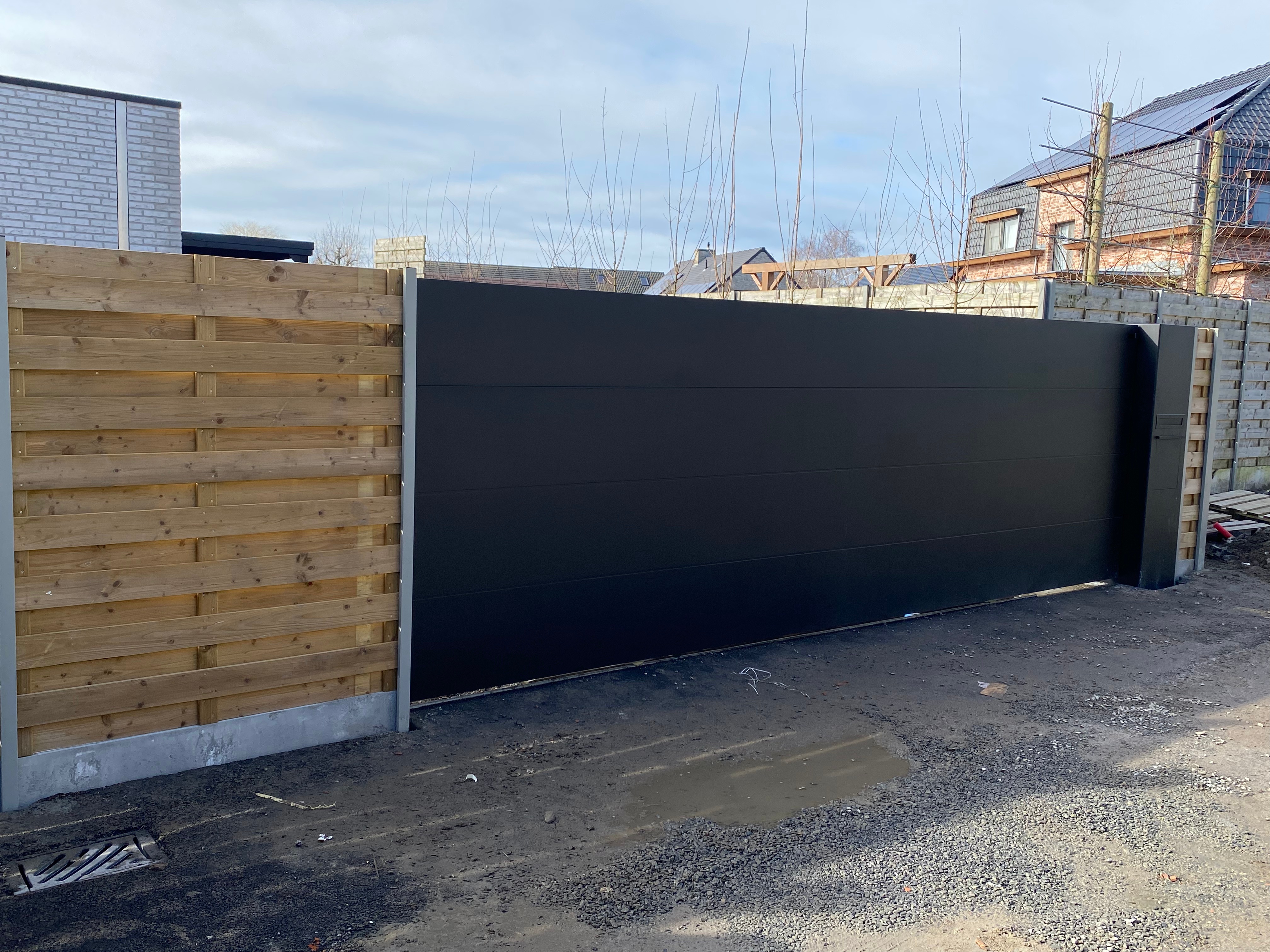 Aluminium schuifpoort met geïntegreerde pakketbrievenbus en automatisatie geplaatst in Handzame.