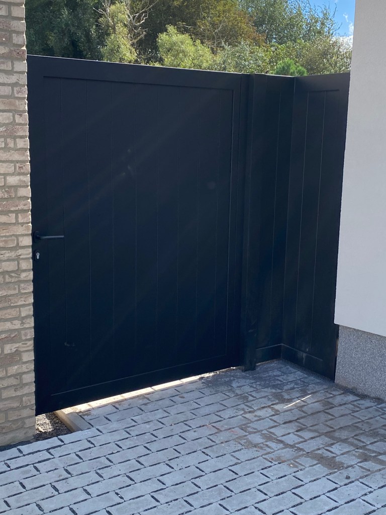 Aluminium tuinpoort met paskader en verticale bekleding, geplaatst in Westende.