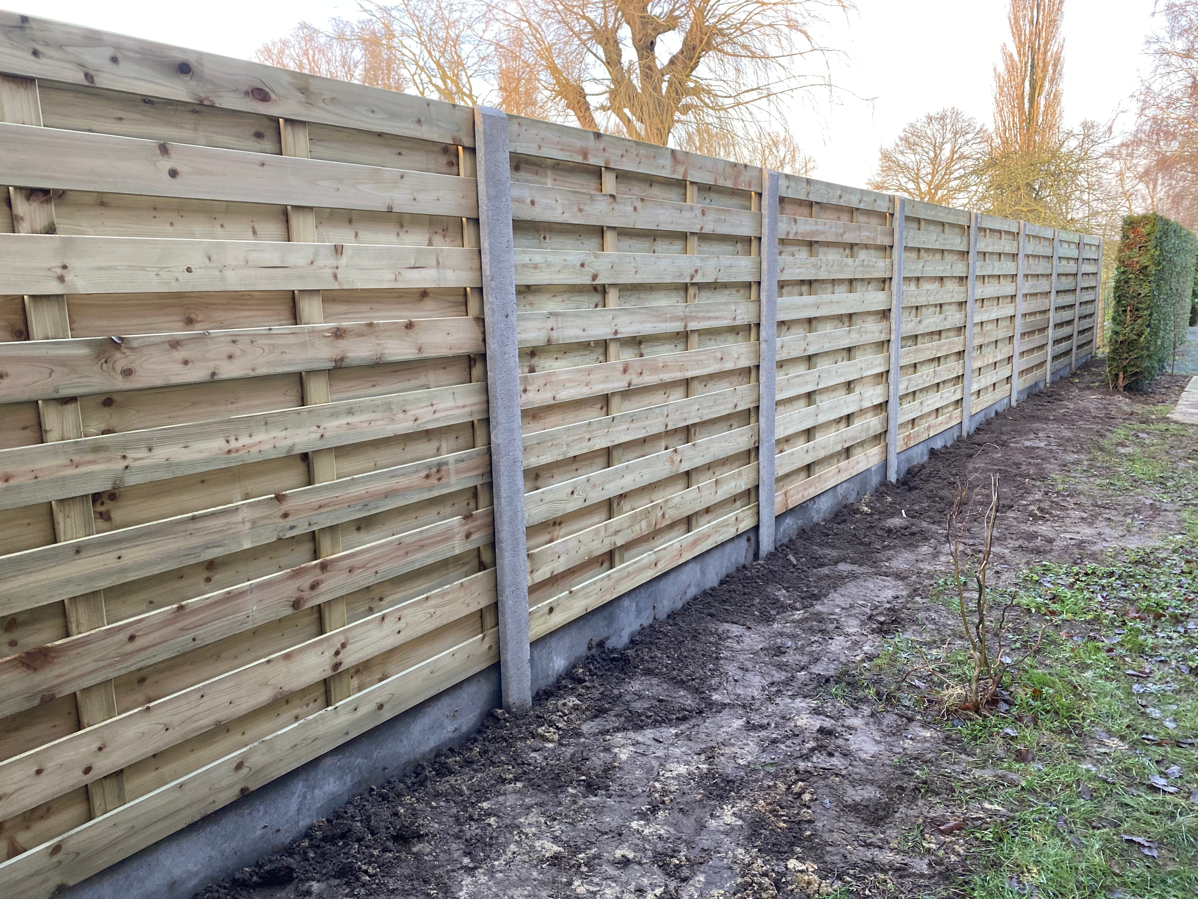 Houten tuinafsluiting met horizontale houten panelen tussen betonpalen, geplaatst in Zarren.